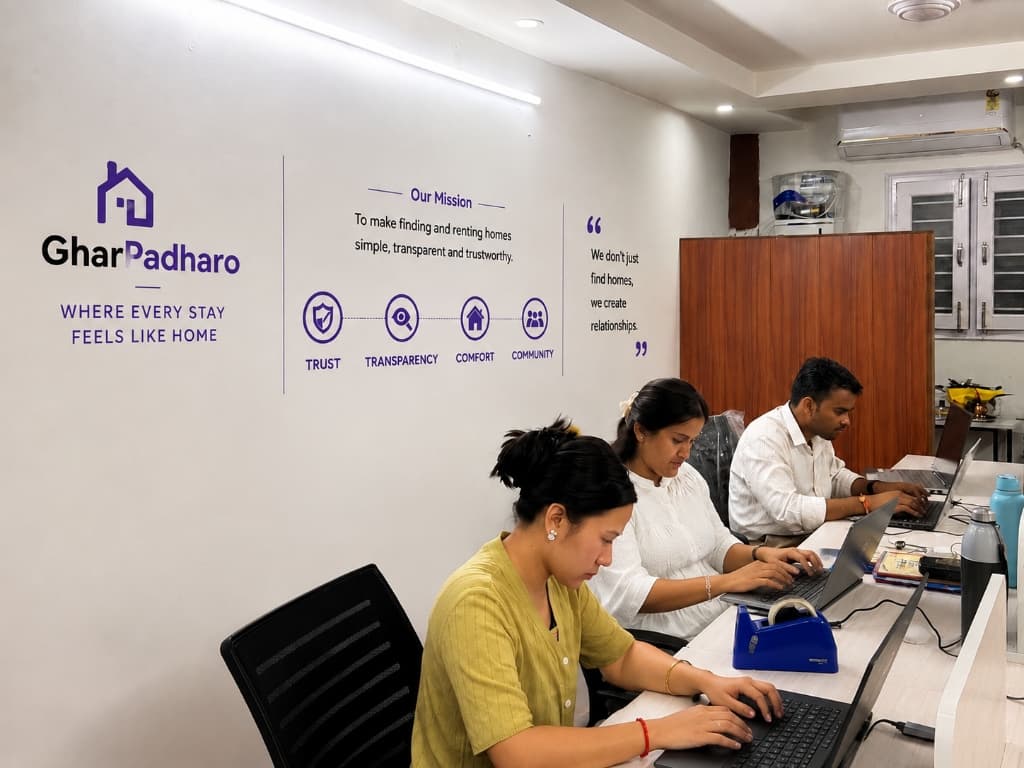 GharPadharo team members collaborating at work along the mission wall