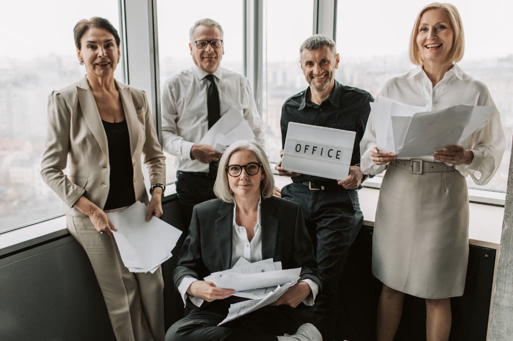 Five colleagues in business attire collaborating in a modern office